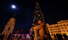 Un couple s'embrasse près d'un arbre de Noël lors d'une célébration de la veille du Nouvel An devant la cathédrale Sainte-Sophie à Kyiv