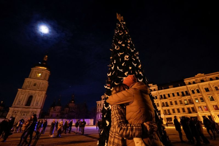 Un couple s'embrasse près d'un arbre de Noël lors d'une célébration de la veille du Nouvel An devant la cathédrale Sainte-Sophie à Kyiv