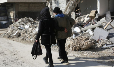 Des gens marchent près des bâtiments endommagés par un tremblement de terre à Jableh, en Syrie