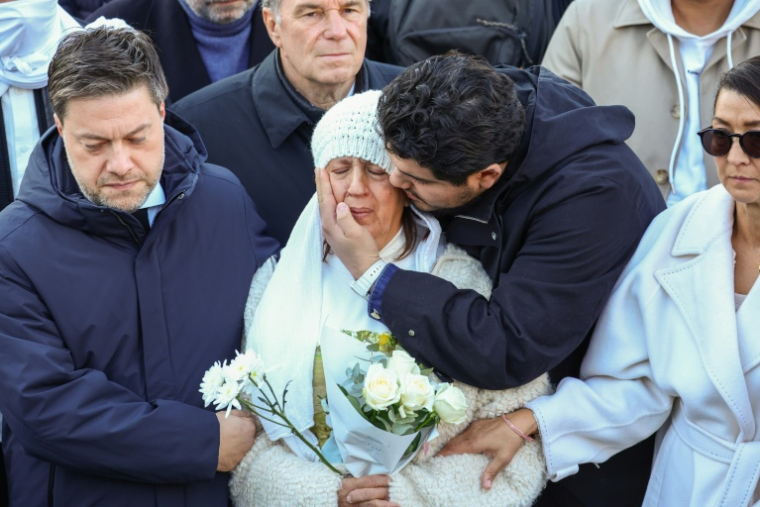 Amine Kessaci (G)console sa mère  Ouassila Benhamdi (C) au côté du maire de Marseille Benoît Payan (D) lors de l'hommage à son fils assassiné Mehdi Kessaci, organisé à Marseille le 22 novembre 2025 ( AFP / CLEMENT MAHOUDEAU )