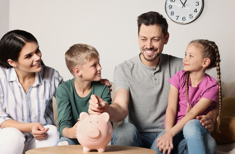 (Crédits photo : Adobe Stock - Parents parlant d'argent aux enfants devant une tirelire)