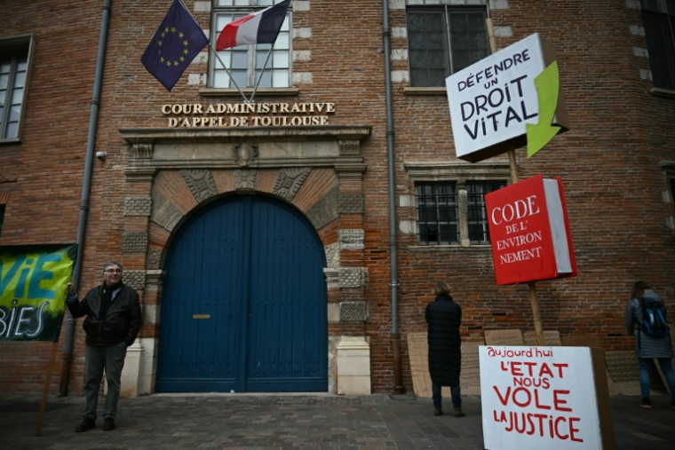 Un homme brandit une pancarte lors d’une manifestation contre le projet d’autoroute A69, devant la cour administrative d’appel à Toulouse, le 11 décembre 2025 ( AFP / Lionel BONAVENTURE )