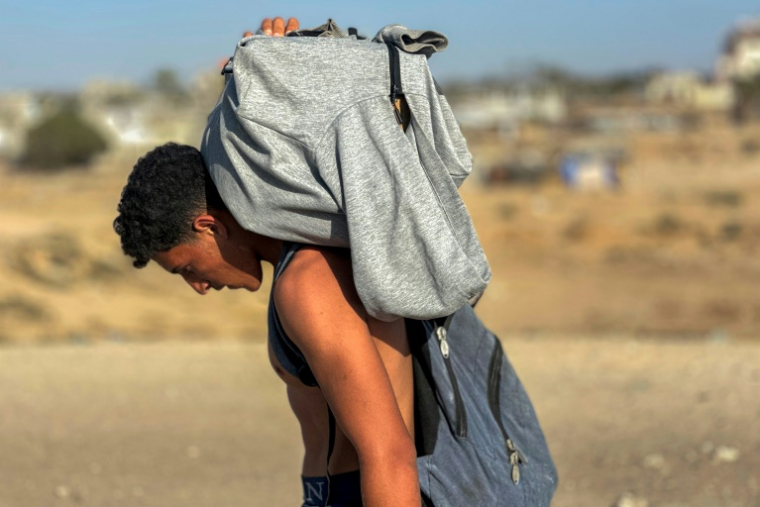 Un Palestinien transporte de l'aide après une distribution par le groupe GHF à Rafah, dans le sud de la bande de Gaza, le 27 mai 2025 ( AFP / - )