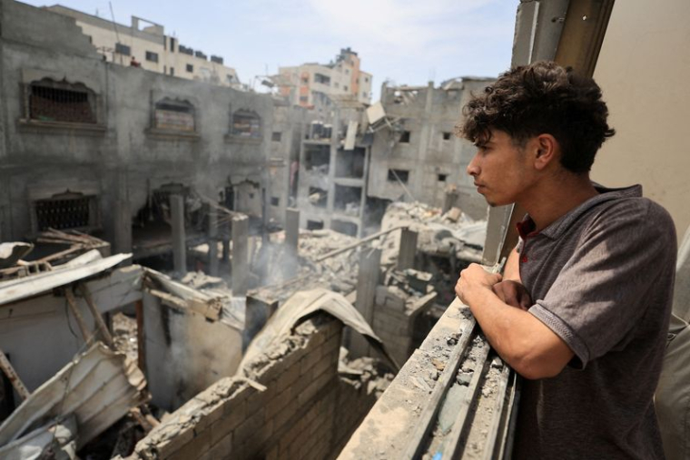 Des Palestiniens inspectent le site d'une frappe aérienne israélienne sur des maisons, dans le camp de réfugiés de Shati (Beach) à Gaza