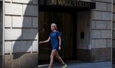 Une piétonne passe devant un bâtiment de Wall Street à New York