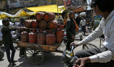 Des travailleurs transportent du gaz naturel liquéfié (GNL) en bonbonnes dans les rues de Delhi, le 10 avril 2026 ( AFP / Arun SANKAR )