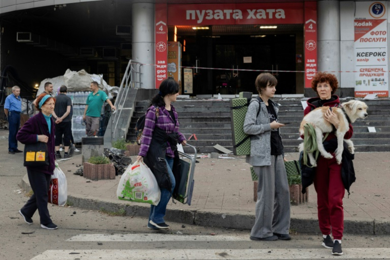 Des habitants sortent d'un abri avec leurs affaires après des frappes nocturnes russes sur Kiev, le 10 juillet 2025 en Ukraine ( AFP / Tetiana DZHAFAROVA )