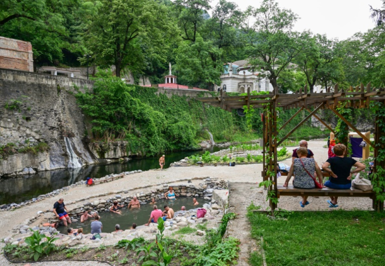 Des touristes profitent des eaux thermales riches en soufre de la ville de Baile Herculane, le 29 juillet 2025 en Roumanie ( AFP / Daniel MIHAILESCU )