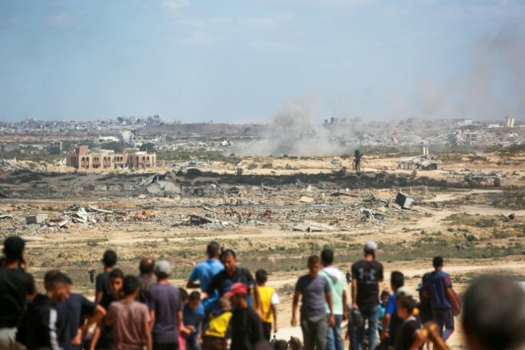 Des Palestiniens observent la fumée dégagée par un bombardement israélien, à Nousseirat, dans le centre de la bande de Gaza, le 1er octobre 2025   ( AFP / Bashar TALEB )