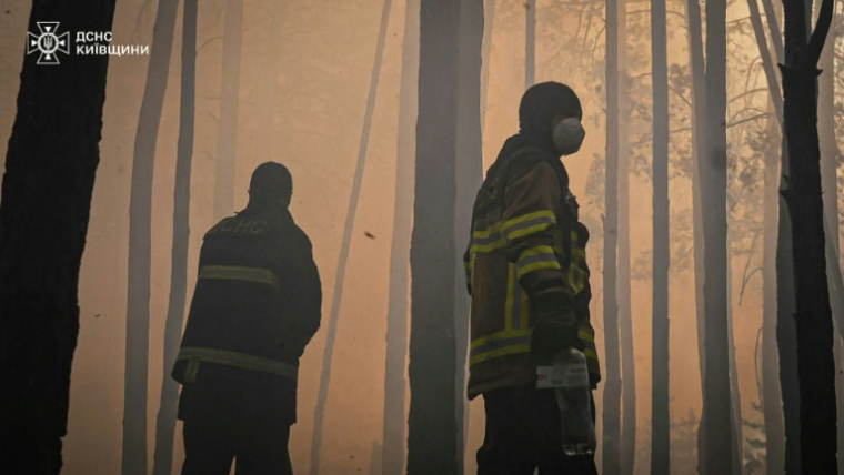 Photo émanant du service des situations d'urgence urkrainien, le 8 mai 2026, montrant des pompiers luttant contre un important feu de forêt dans la zone interdite de Tchernobyl, dans le nord de l'Ukraine  ( STATE EMERGENSY SERVICE OF UKRAINE / Handout )