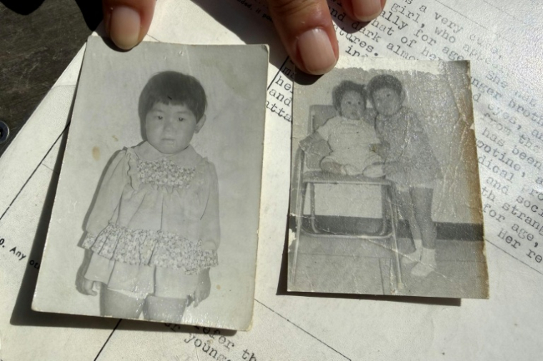 Sofie Randel, d'origine coréenne, montre une photo d'elle seule et une autre avec son  frère, le 9 mai 2026 à Kastrup, près de Copenhague, au Danemark ( AFP / Camille BAS-WOHLERT )