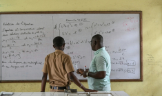 Un professeur de mathématiques (à droite) explique un exercice à un élève de terminale scientifique dans un lycée du quartier de Cocody, à Abidjan (Côte d'Ivoire), le 22 septembre 2026 ( AFP / Sia KAMBOU )
