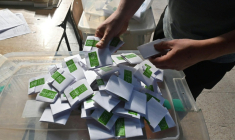Un homme compte les bulletins dans un bureau de vote lors des élections générales, à Santiago, le 16 novembre 2025 ( AFP / Victor RUIZ )
