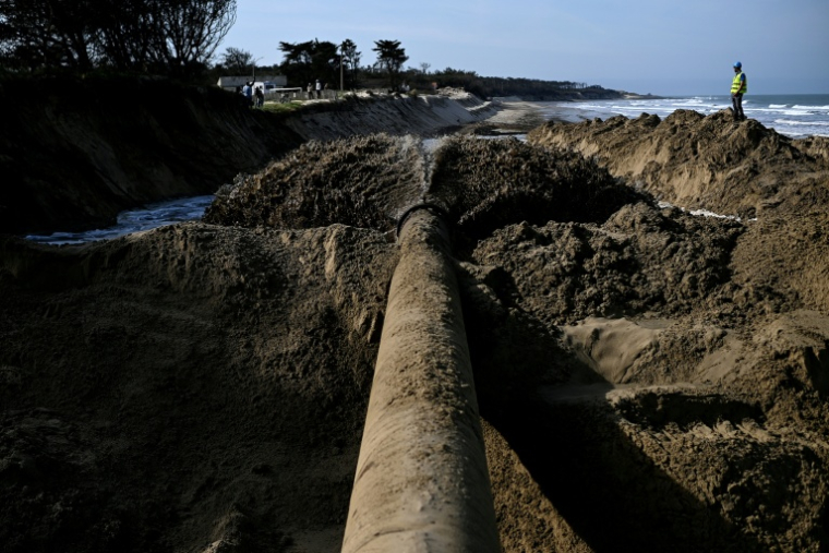 Un mélange de sable et d'eau est expulsé d'un tuyau dans le cadre d'une expérimentation de lutte contre l'érosion marine, à Soulac-sur-Mer, en Gironde, le 10 avril 2026 ( AFP / Christophe ARCHAMBAULT )