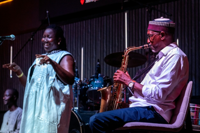 Le saxophoniste Thierno Koité, du groupe  Orchestra Baobab, se produit aux côtés de la chanteuse Korka Dieng, lors d'un concert au club Just For You le 27 septembre 2026 à Dakar, au Sénégal ( AFP / SEYLLOU )