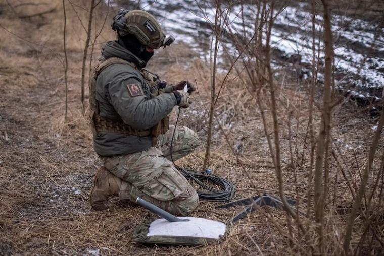 Un soldat ukrainien de la 47e brigade prépare un système internet par satellite Starlink à son poste sur la ligne de front près de la ville d'Avdiivka