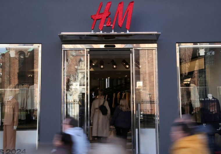 Des personnes passent devant une boutique de la chaine de prêt-à-porter H&M à Copenhague
