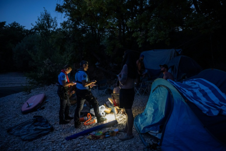 Des gendarmes contrôlent des touristes lors d'une opération de prévention contre les bivouacs illégaux susceptibles de provoquer un départ de feu, le 8 août 2026 autour du lac de Sainte-Croix, aux portes des Gorges du Verdon ( AFP / Miguel MEDINA )