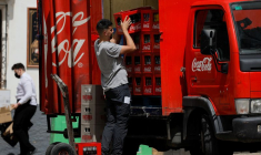 Un livreur décharge des caisses de bouteilles Coca-Cola d'un camion à Ronda, en Espagne