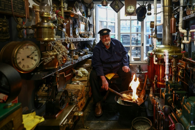 Peter McLaughlin dans son abri de jardin, aménagé pour reproduire la chaufferie d'un navire, à l'arrière de sa maison à Londres, le 31 juillet 2026 ( AFP / Henry NICHOLLS )