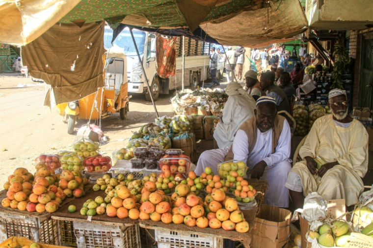 Des vendeurs de fruits assis devant leurs étals sur le marché central de Khartoum au Soudan, le 17 janvier 2025 ( AFP / Ebrahim HAMID )