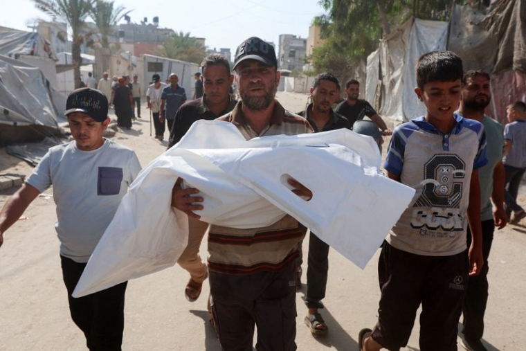 Un proche de la défunte porte le corps de la jeune Palestinienne Rateel Al-Balawi, tuée lors d'une frappe israélienne sur une tente, selon les secouristes, lors de ses funérailles à Khan Younis