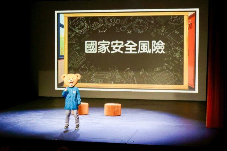 La mascotte du Bureau de la sécurité de Hong Kong, "l'ours de la sécurité", apparaît sur scène dans une pièce interactive sur le thème de la sécurité nationale à Hong Kong, le 11 novembre 2025 ( AFP / Tommy WANG )
