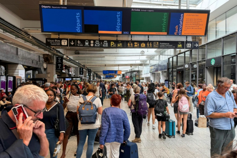 Des passagers patientent à la gare Montparnasse à Paris le 27 août 2026 ( AFP / Olivier MORIN )