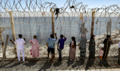 Des personnes attendent derrière une clôture surmontée de barbelés le retour de proches ayant tenté de franchir la frontière pour entrer dans l’enclave espagnole de Ceuta, le 2 août 2026 à Fnideq ( AFP / Abdel Majid BZIOUAT )