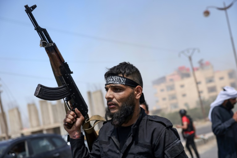 Un bédouin lève son arme dans les rues de la partie nord de la ville de Soueida, dans le sud de la Syrie, le 19 juillet 2025 ( AFP / Bakr ALkasem )