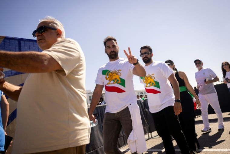 Des supporters iraniens font la queue pour rentrer dans le SoFi Stadium, près de Los Angeles, avec le drapeau utilisé par l'Iran avant la révolution islamique, le 15 juin 2026 ( AFP / ETIENNE LAURENT )
