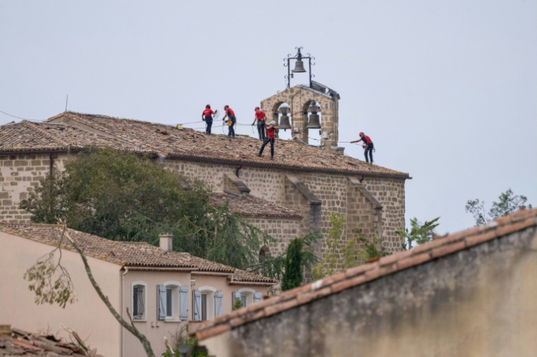 Des pompiers du Groupe de reconnaissance et d'intervention en milieu périlleux (Grimp) sur le toit d'une église à Pomas, dans l'Aude, le 26 août 2026 ( AFP / Idriss Bigou-Gilles )