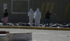 Des experts médicolégaux procèdent à l'identification de corps étendus au sol dans une morgue de fortune située dans le port de La Guaira, au Venezuela, le 29 juin 2026 ( AFP / Federico PARRA )