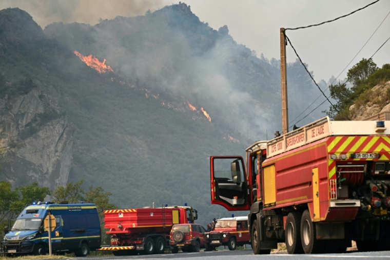 Des camions de pompiers stationnés devant un incendie de forêt près de Fraissé-des-Corbières, le 6 août 2025 ( AFP / Lionel BONAVENTURE )