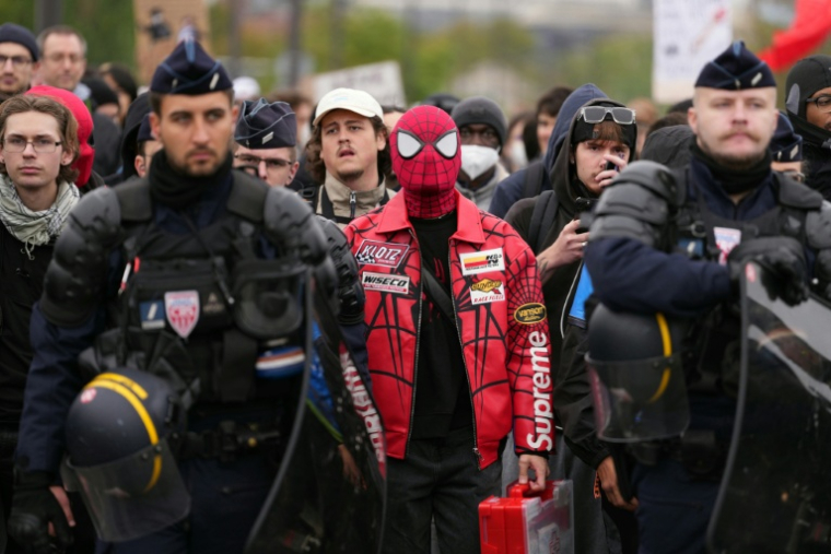 Un manifestant costumé en Spiderman derrière des CRS, le 24 octobre 2026 à Paris ( AFP / Dimitar DILKOFF )