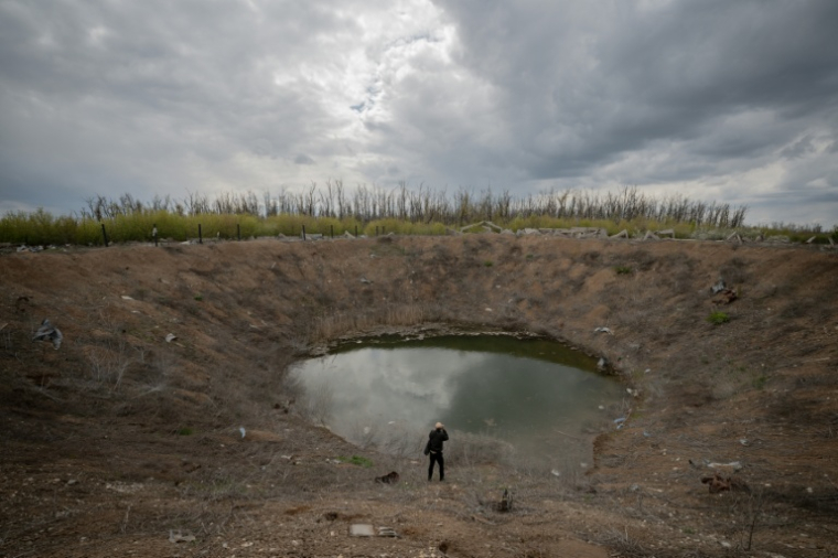 Un cratère formé par un bombardement en 2022 dans le village de Dovhen'ke, dans la région de Kharkiv, le 1er mai 2026 ( AFP / Ivan SAMOILOV )