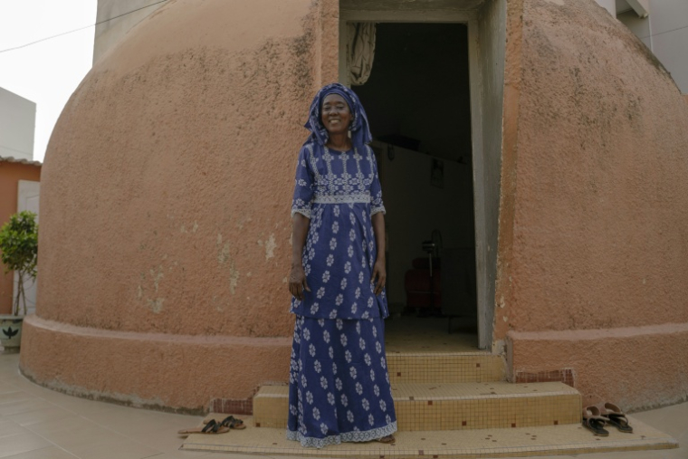 La retraitée sénégalaise Marieme Ndiaye, 65 ans, à l'entrée de sa "maison-bulle" de Dakar, le 31 août 2025 ( AFP / Carmen Abd Ali )