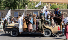 Des Afghans sur un véhicule des membres des forces de sécurité talibanes lors des célébrations du cinquième anniversaire de leur retour au pouvoir à Kaboul, le 15 août 2026 ( AFP / Mohsen KARIMI )