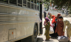 Des rapatriés afghans montent dans un bus à leur arrivée du Pakistan, près du poste-frontière de Torkham, le 24 juin 2026 ( AFP / Aimal ZAHIR )