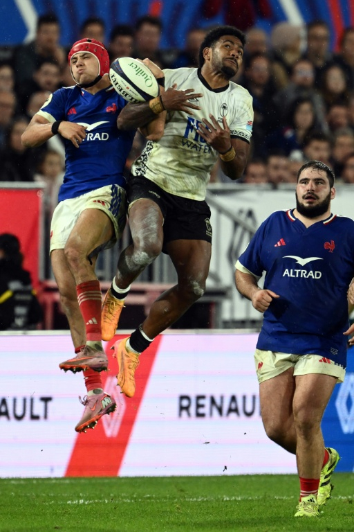 Le Fidjien Josua Tuisova (C) et le Français Louis Bielle-Biarrey se disputent le ballon lors de la victoire remportée par le XV de France (34-21), le 15 novembre 2025 à Bordeaux ( AFP / Philippe LOPEZ )