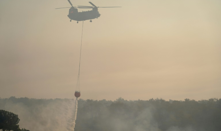 Un hélicoptère participe aix opérations pour éteindre les flammes après un feu de forêt dans le village chypriote de Souni, dans la province de Limassol, le 24 juillet 2025 ( AFP / Etienne TORBEY )