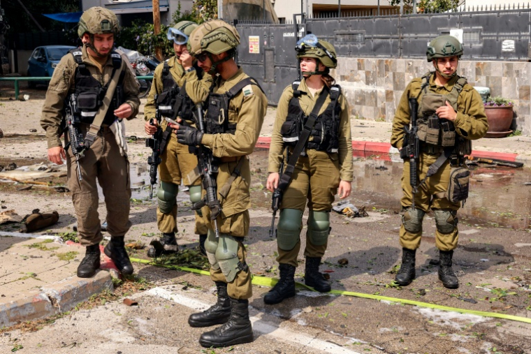 Des militaires israéliens sur les lieux d'une frappe iranienne à Holon, dans le district de Tel-Aviv, le 15 mars 2026 ( AFP / Jack GUEZ )