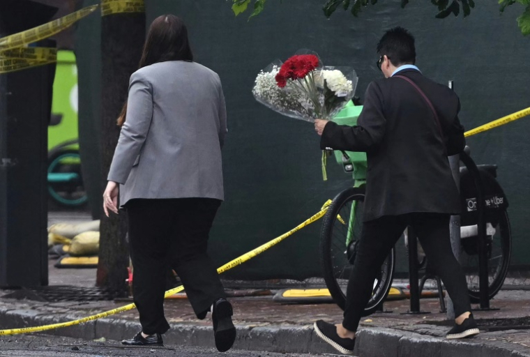 Des personnes apportent des fleurs devant le Musée juif de Washington où des tirs ont fait deux morts, le 22 mai 2025 ( AFP / Drew ANGERER )