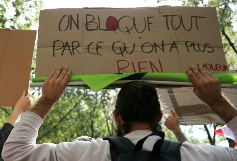 Un manifestant arbore une pancarte "on bloque tout parce qu'on a plus rien" le 10 septembre 2025 à Paris ( AFP / Thomas SAMSON )