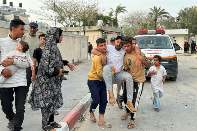Un blessé est pris en charge par des habitants après une frappe israélienne à Khan Younès, dans le sud de la bande de Gaza, le 13 mai 2025 ( AFP / - )
