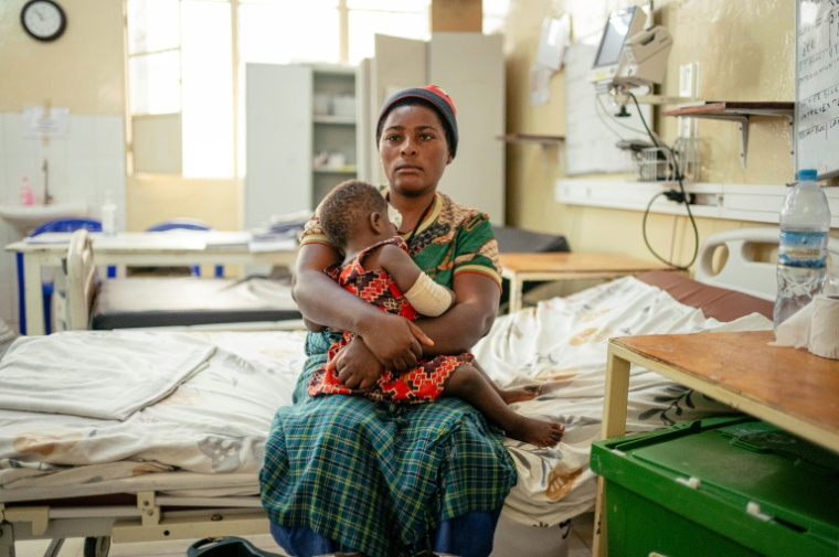 Espérance tient dans ses bras sa fillette blessée lors du bombardement du marché de Mushaki, à l'hôpital de Goma, soutenu par le Comité international de la Croix-Rouge (CICR), le 14 mai 2026 en RDC ( AFP / Jospin Mwisha )