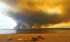 Vue d'un épais nuage de fumée dû aux feux de forêts depuis la plage du Moutchic sur le lac de Lacanau, en Gironde, le 24 juillet 2026 ( AFP / Maximilien LAMY )