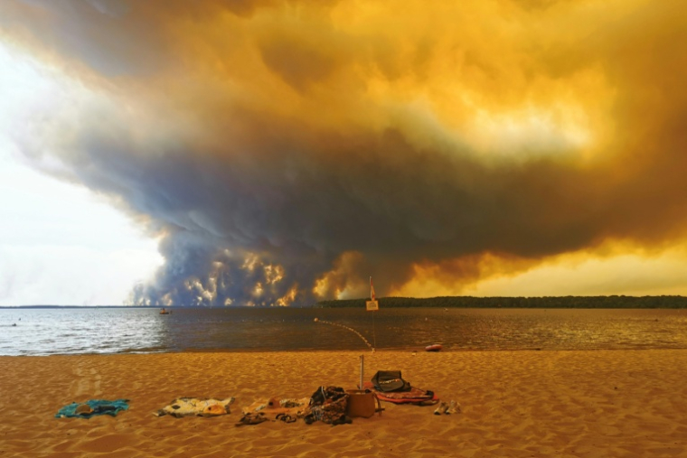 Vue d'un épais nuage de fumée dû aux feux de forêts depuis la plage du Moutchic sur le lac de Lacanau, en Gironde, le 24 juillet 2026 ( AFP / Maximilien LAMY )