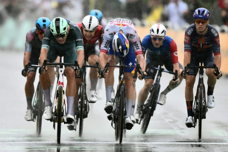L'Italien Jonathan Milan (D) s'impose devant le Belge Jordi Meeus (C) au sprint lors de la 17e étape du Tour de France à Valence, le 23 juillet 2025 ( AFP / Marco BERTORELLO )