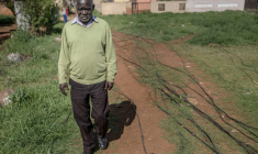 Un habitant du township de Katlehong, près de Johannesburg, marche à côté des câbles qui raccordent illégalement son quartier au réseau électrique, le 5 octobre 2026 ( AFP / EMMANUEL CROSET )